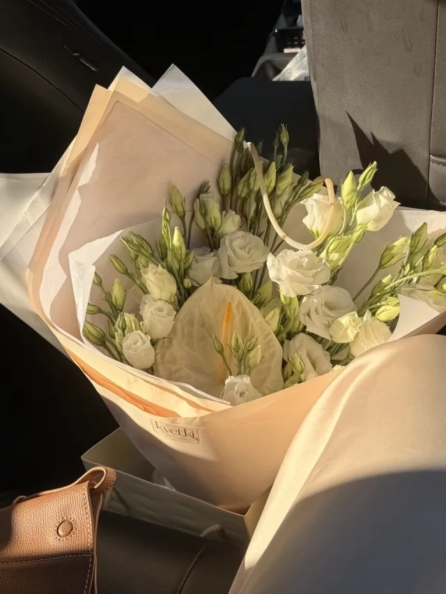 Ivory anthurium and white lisianthus bouquet in blush wrapping