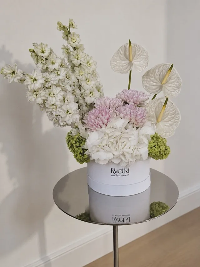 White sculptural flower box with anthuriums and delphinium