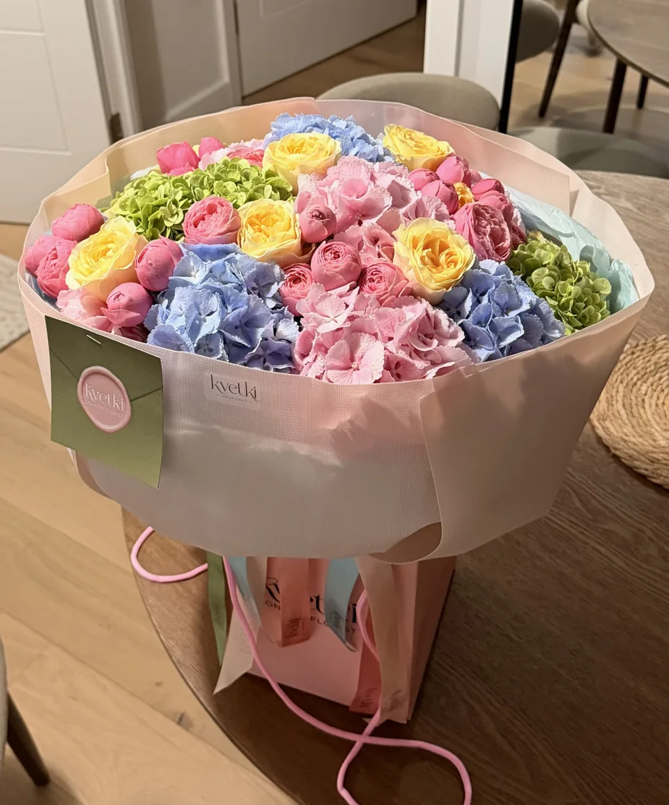 Large pastel bouquet with pink, blue and green hydrangeas and yellow and pink roses