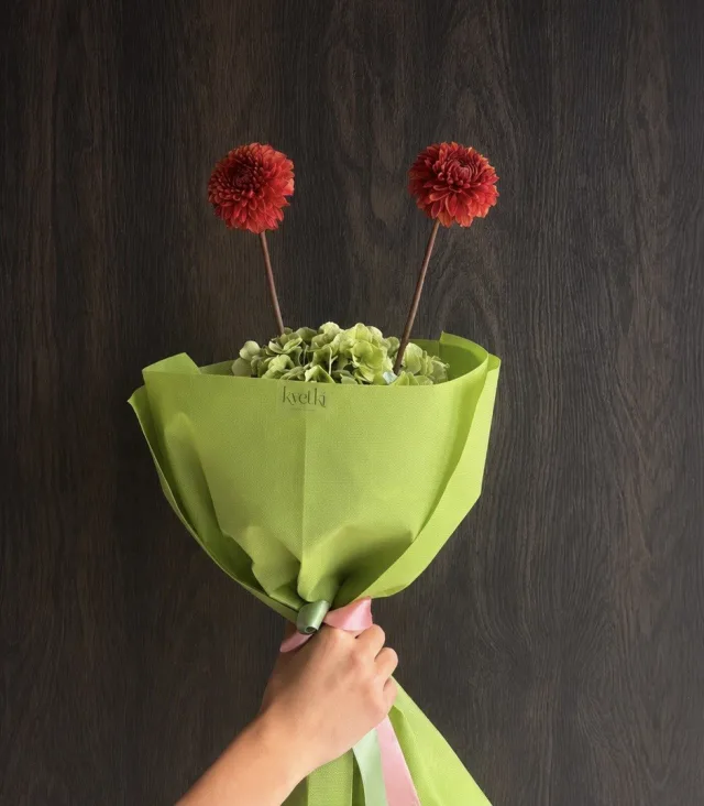 Minimal two-flower bouquet in vivid green wrapping