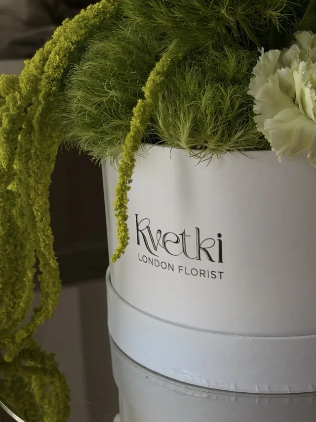 Sculptural green and white flower box with calla lilies